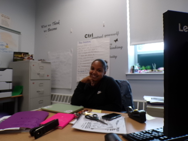 Ms Beckles posing at her desk .
